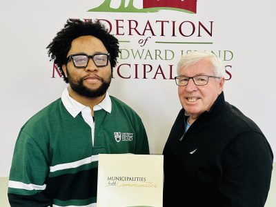 FPEIM President Bruce MacDougall is shown congratulating Joshua Maduka on receiving the FPEIM Gilbert C. Bell Memorial Award.